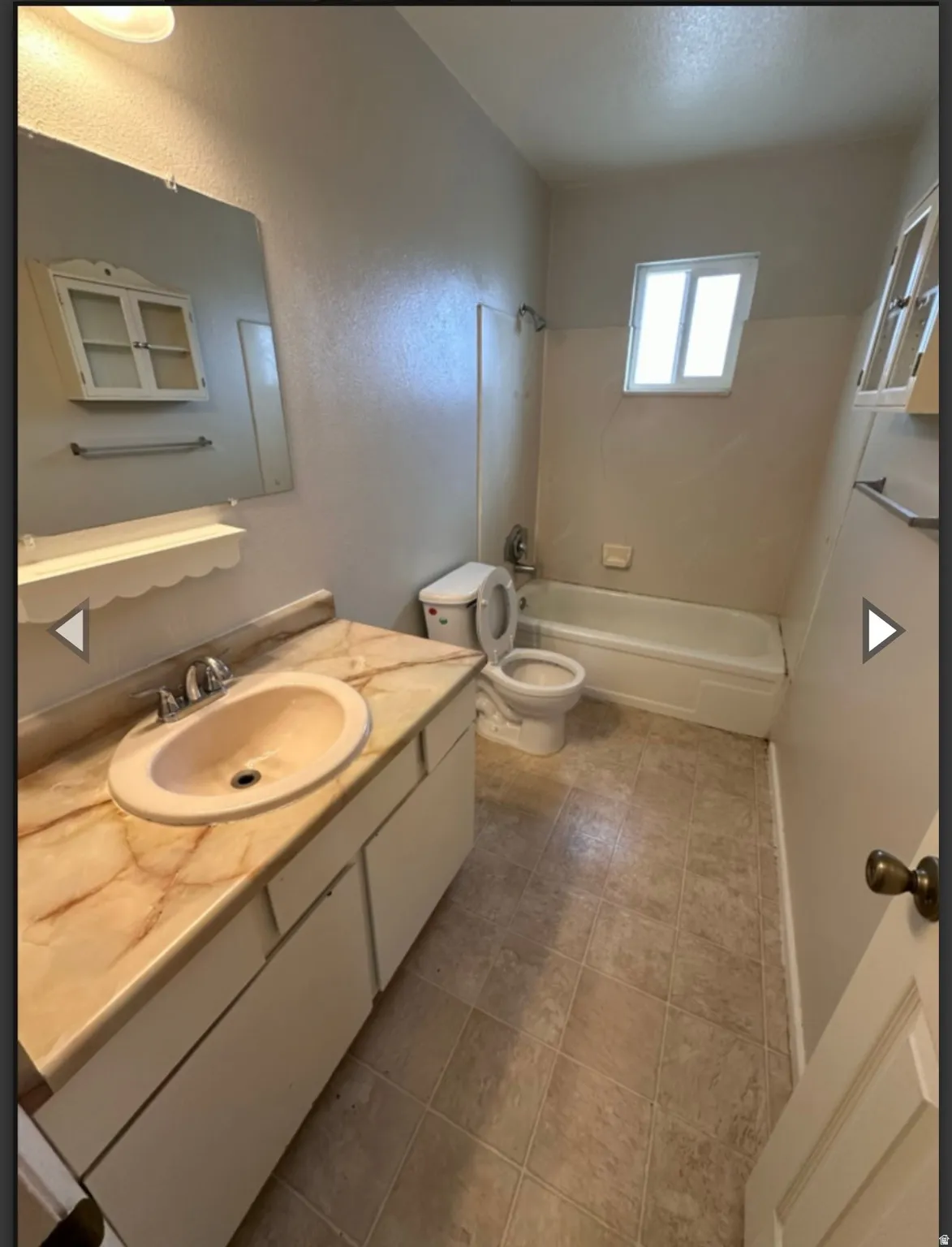 Full bathroom with vanity,  shower combination, and a textured wall