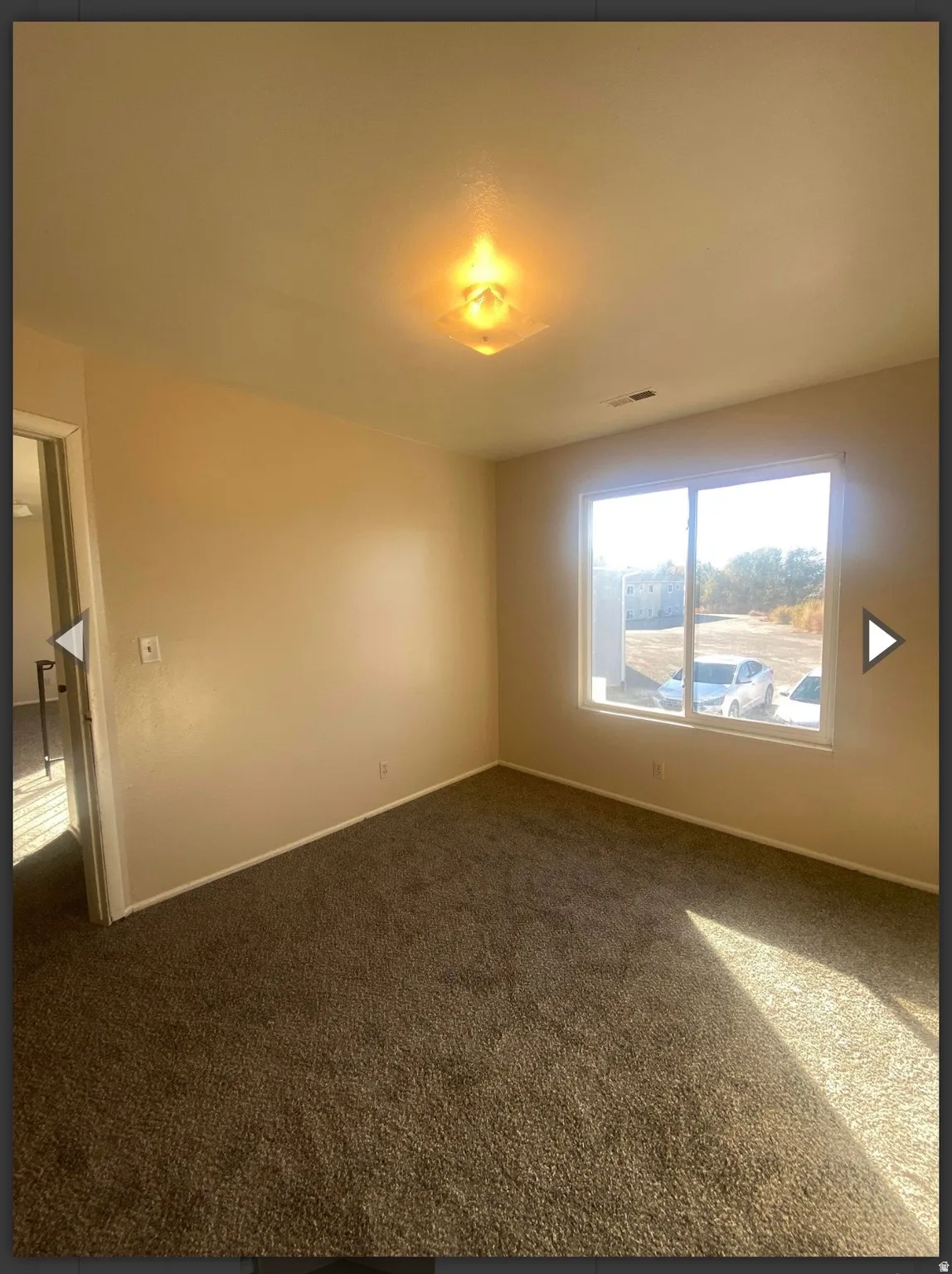 Spare room with dark colored carpet and baseboards