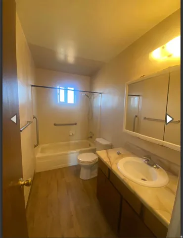 Full bathroom with vanity, dark wood-style flooring, and bathing tub / shower combination