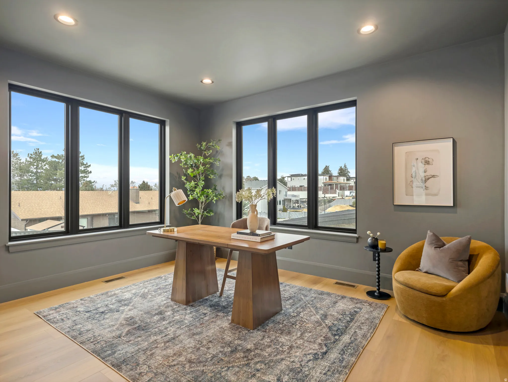 Office with light wood finished floors and recessed lighting
