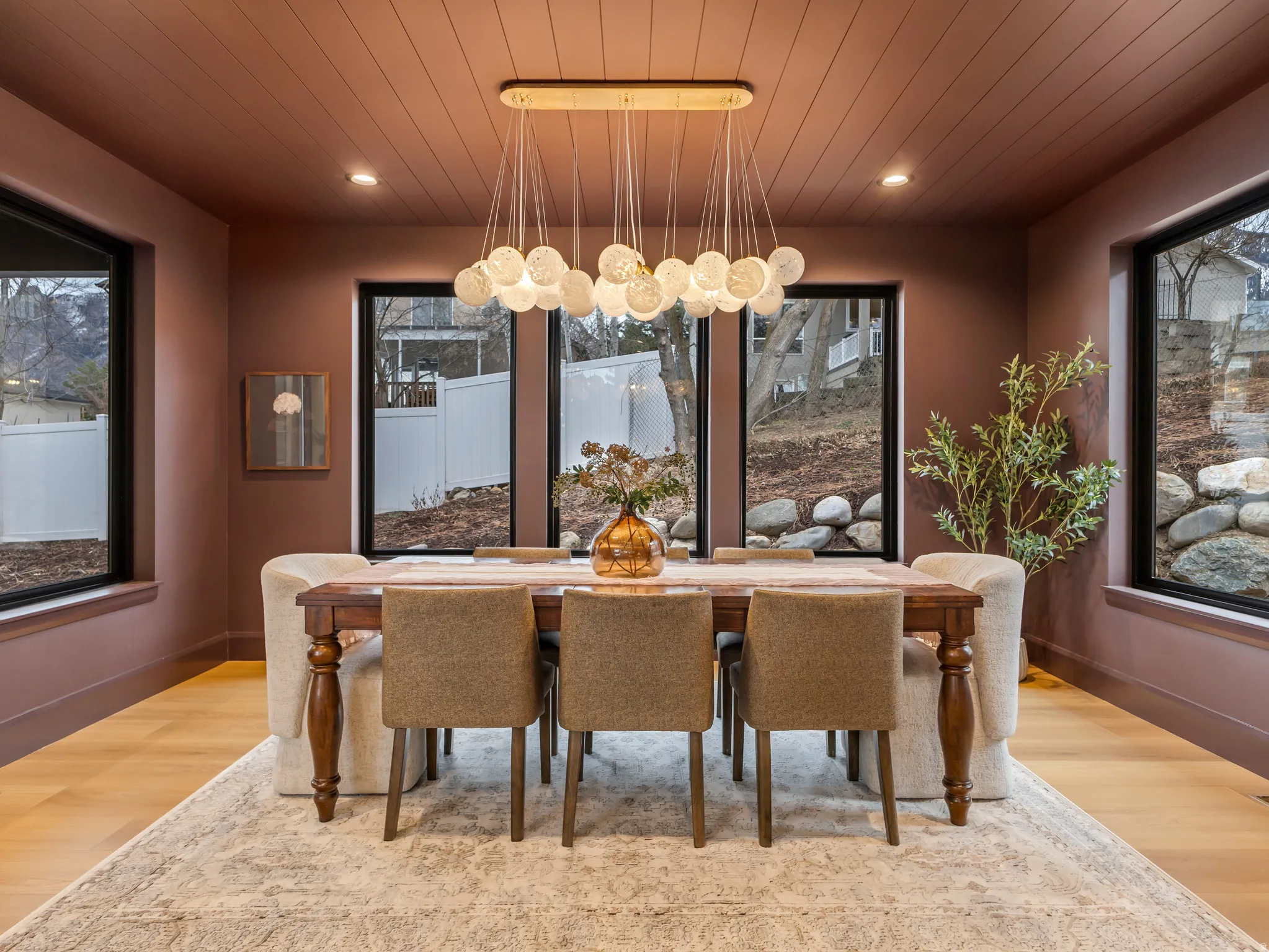 Dining space with light wood finished floors, wood ceiling, a chandelier, and healthy amount of natural light