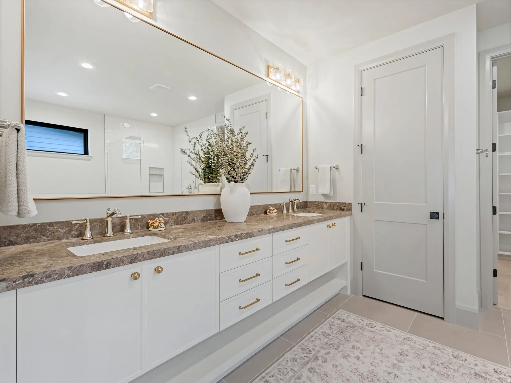 Bathroom featuring double vanity, light tile patterned floors, a walk in shower, and recessed lighting