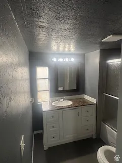 Full bath featuring vanity, shower / tub combination, and dark tile patterned flooring