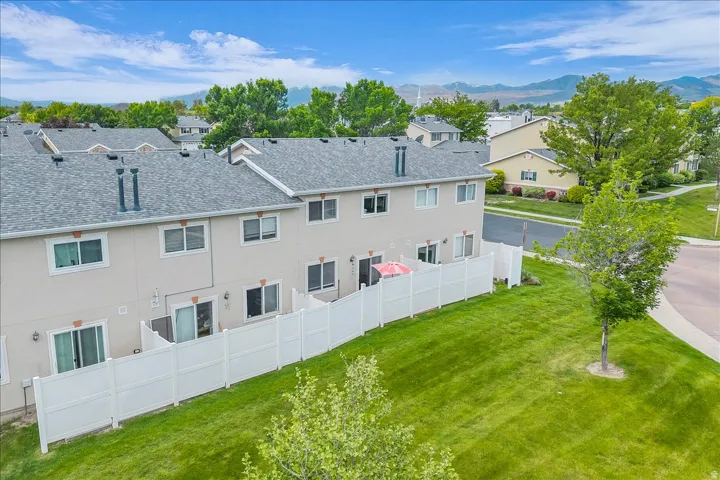 Back of property with stucco siding, a mountain view, and a shingled roof