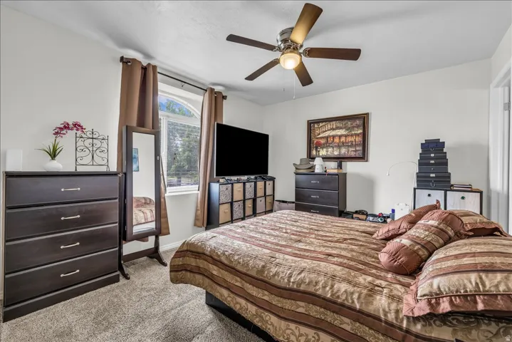 Bedroom featuring light carpet and ceiling fan