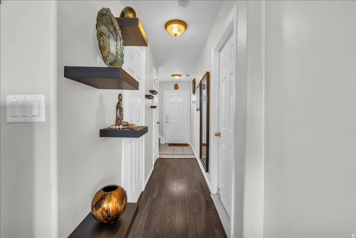 Hallway featuring dark wood-style floors and baseboards
