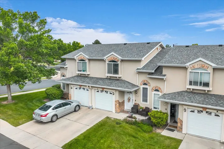 Traditional home featuring stucco siding, an attached garage, and a front yard
