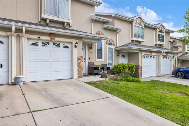 Traditional-style home featuring stucco siding, a garage, concrete driveway, and a front yard