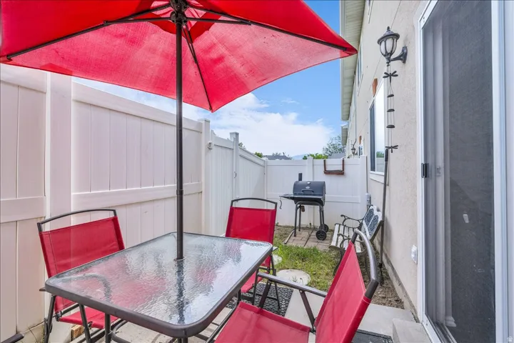 Fenced backyard featuring a patio, outdoor dining area, and grilling area