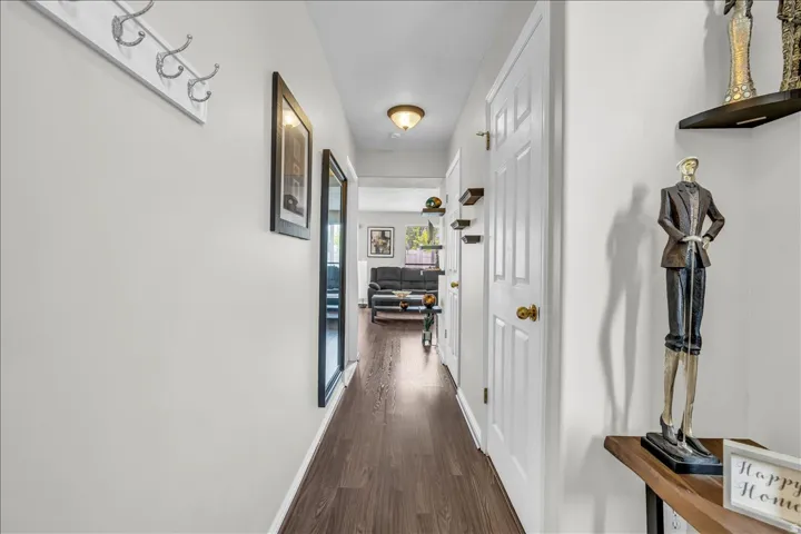 Hallway featuring dark wood-style flooring and baseboards