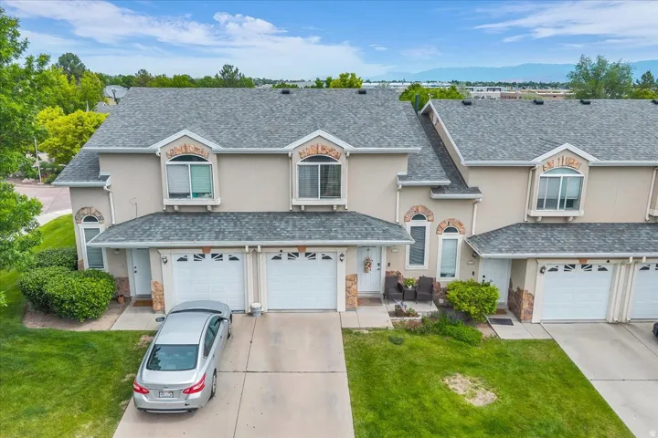 Traditional home with stucco siding, an attached garage, and stone siding