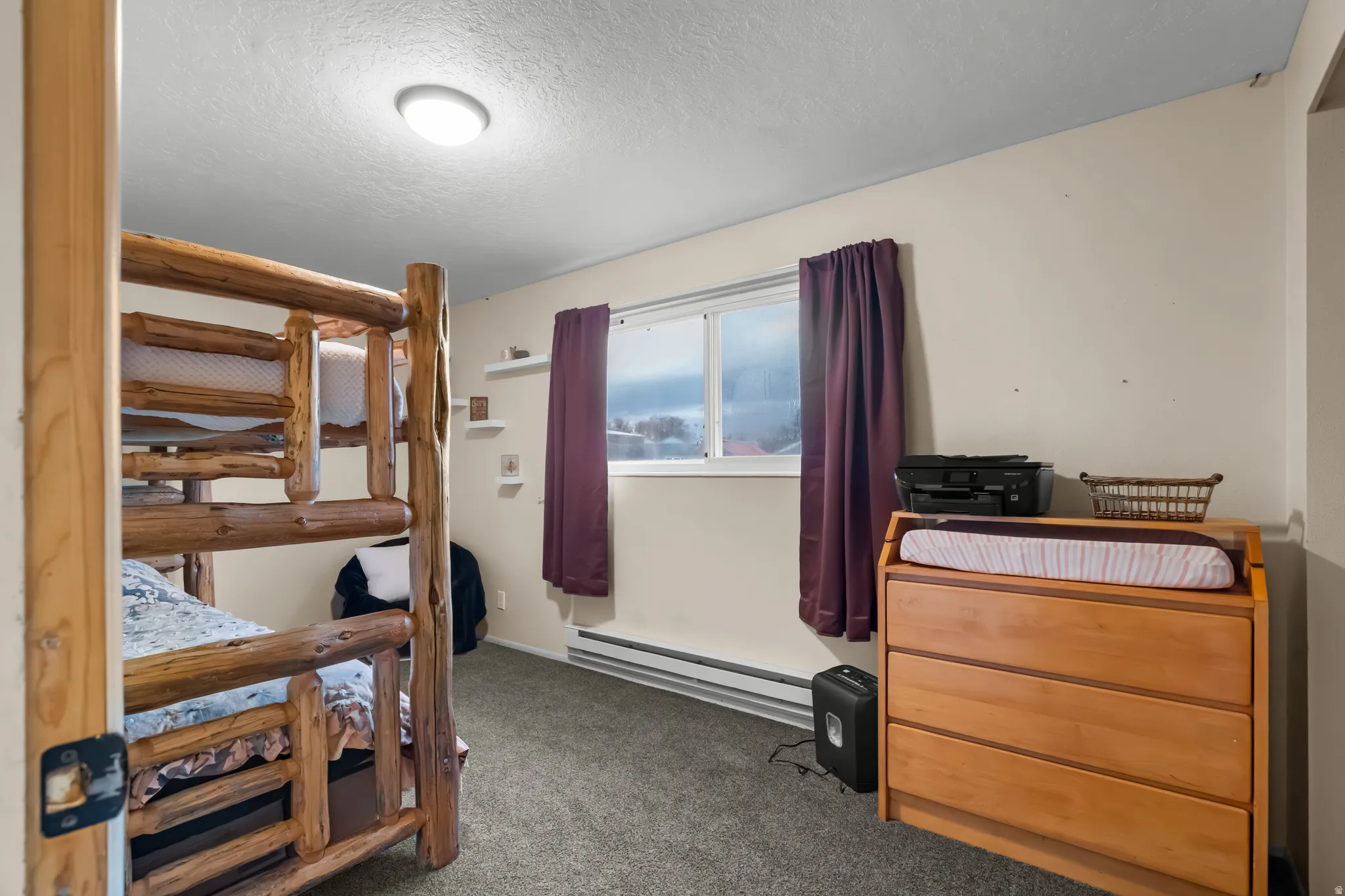Bedroom featuring a textured ceiling, carpet flooring, and baseboard heating