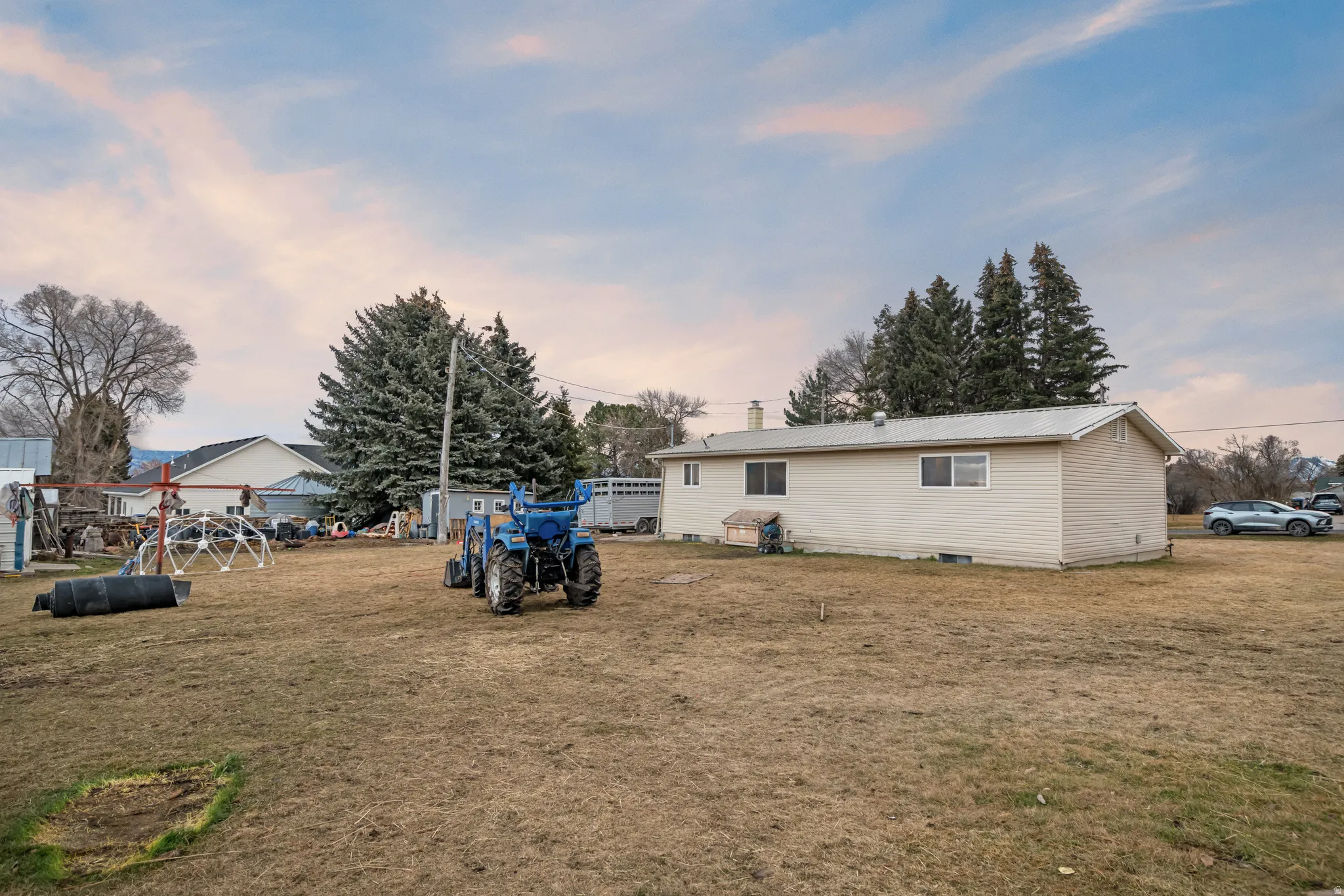 Back of property at dusk featuring a metal roof and a lawn