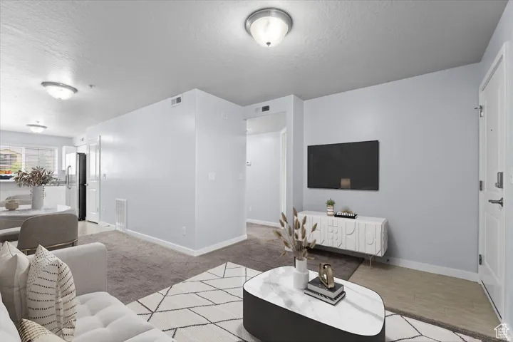 Living room with a textured ceiling and baseboards