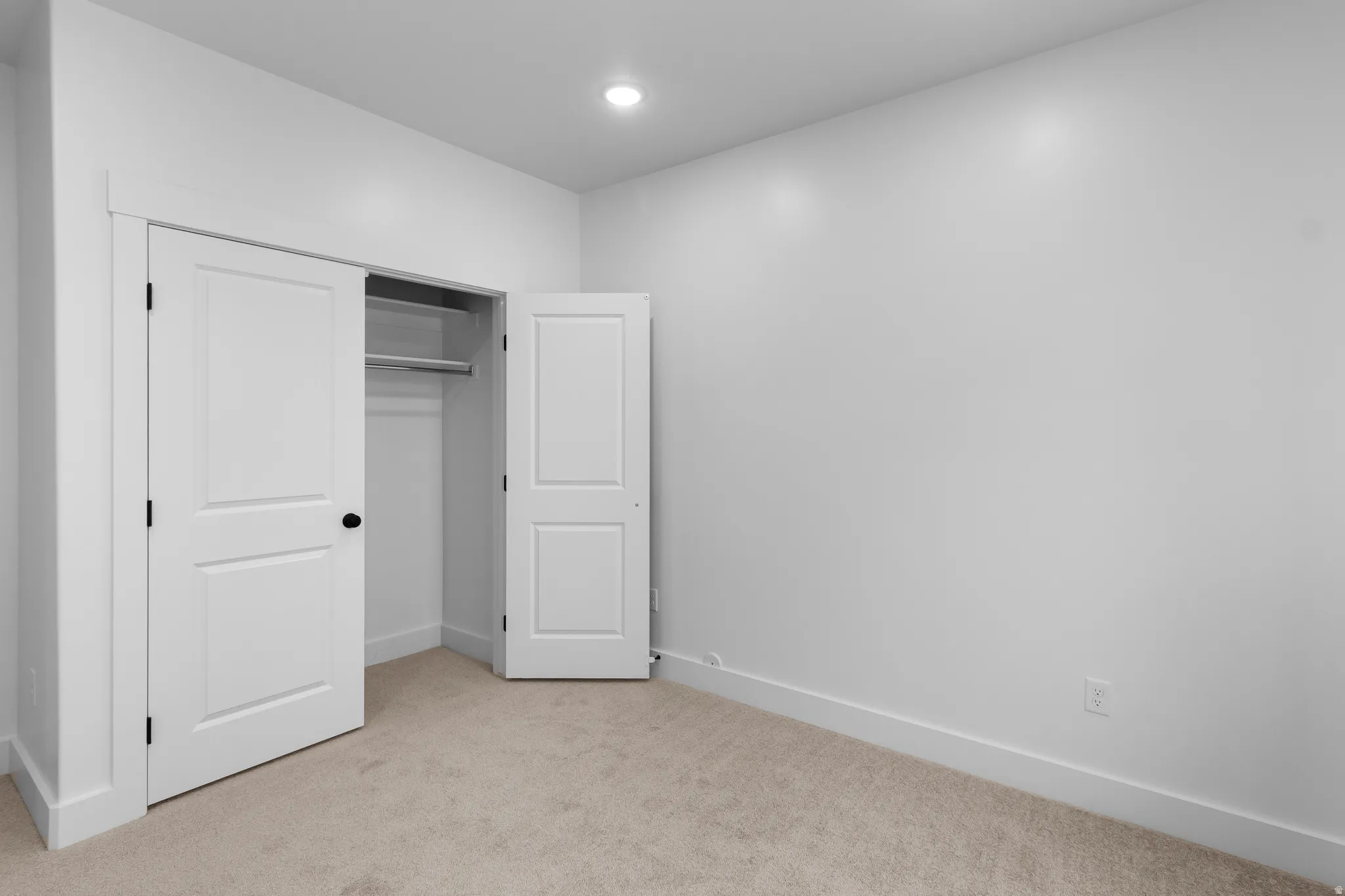 Unfurnished bedroom with light carpet, a closet, and recessed lighting
