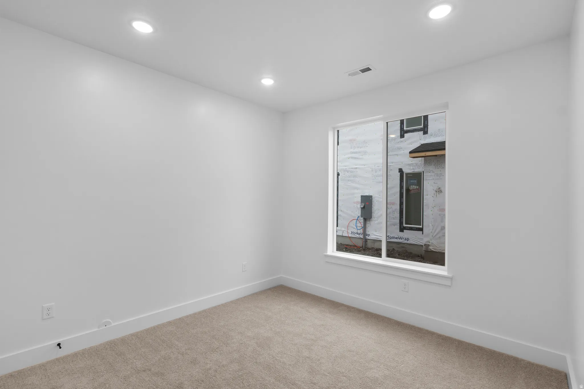 Carpeted empty room featuring baseboards and recessed lighting