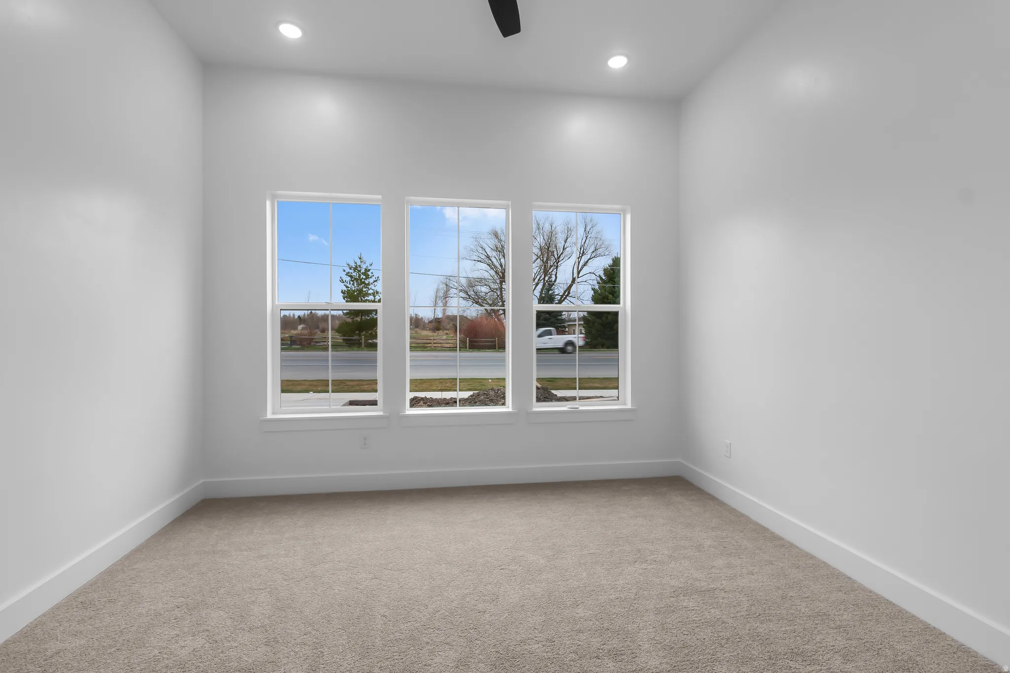 Unfurnished room with light colored carpet, a ceiling fan, and recessed lighting