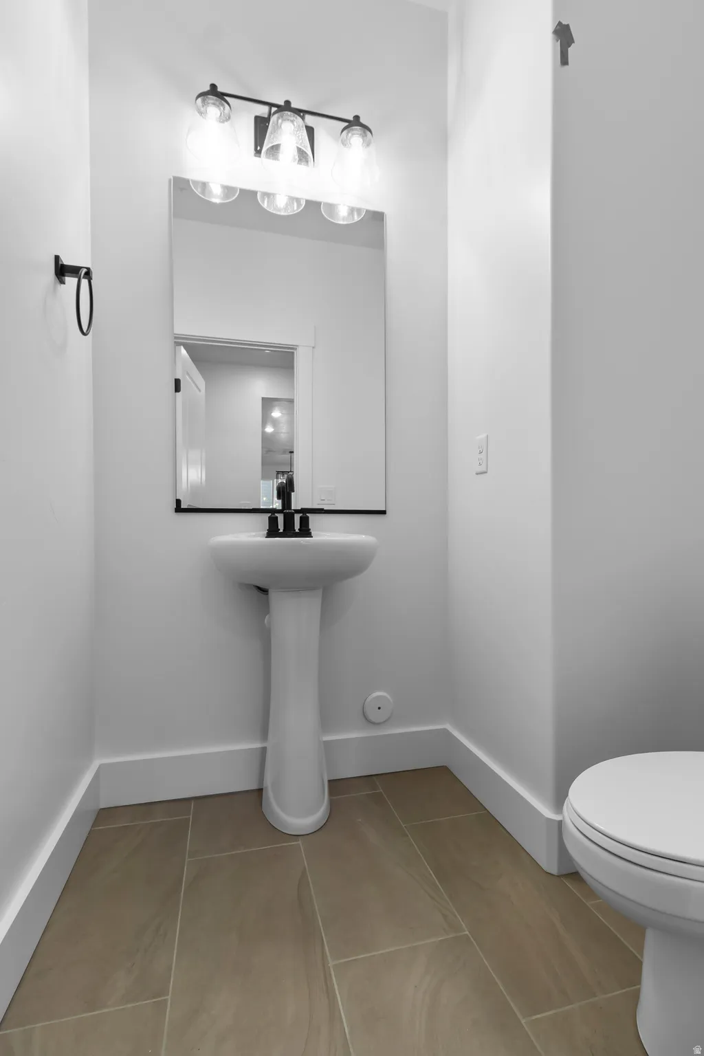 Half bath with light tile patterned flooring