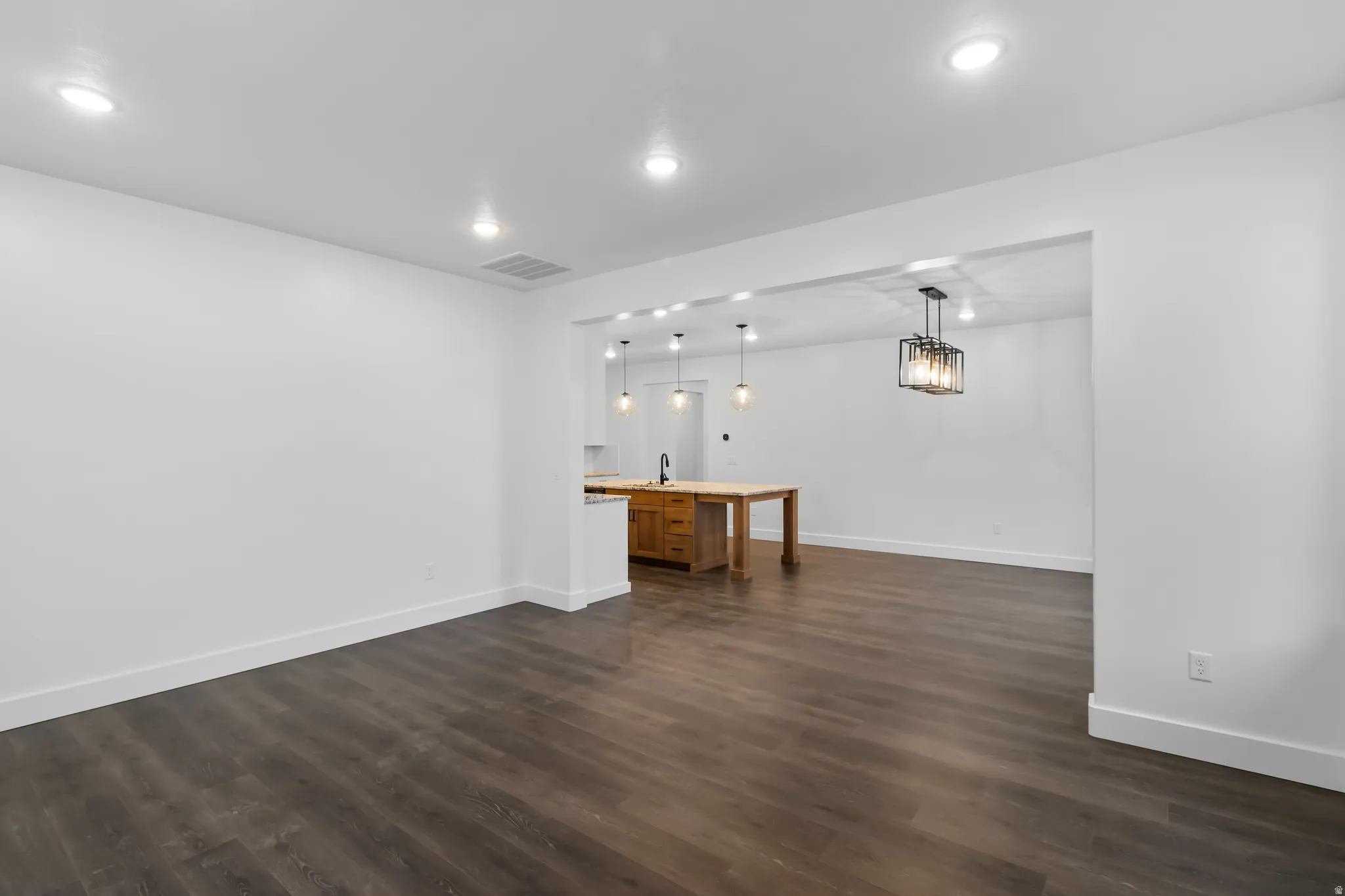 Unfurnished living room with dark wood-style flooring and recessed lighting