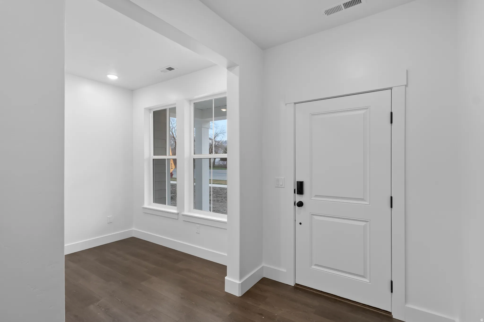 Foyer entrance with dark wood-style floors and recessed lighting