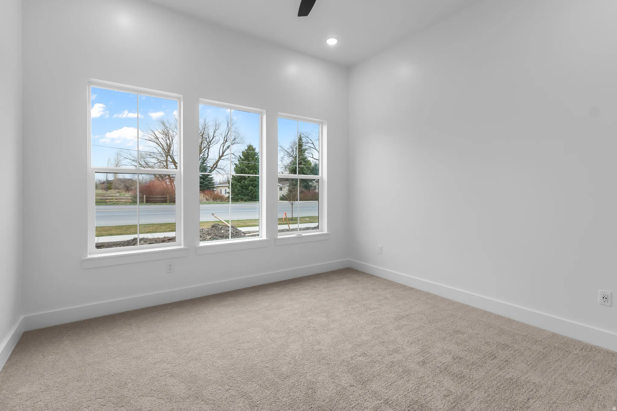 Unfurnished room with light colored carpet, a ceiling fan, and recessed lighting