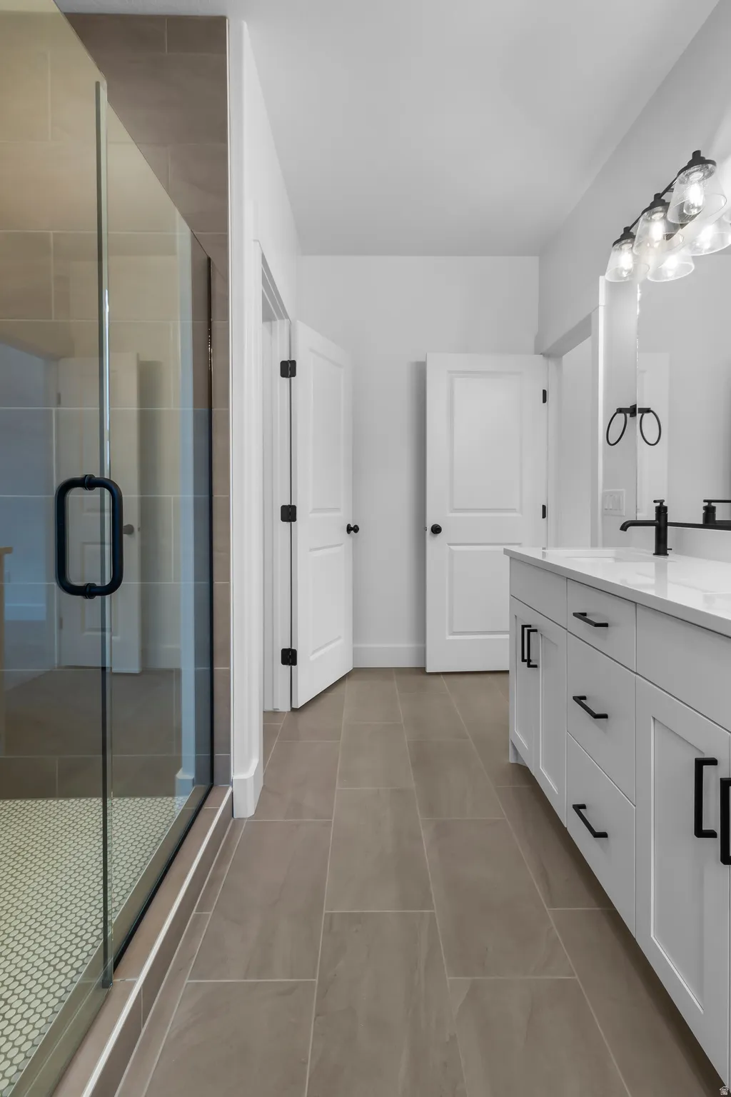 Full bath featuring vanity, a shower stall, and light tile patterned floors