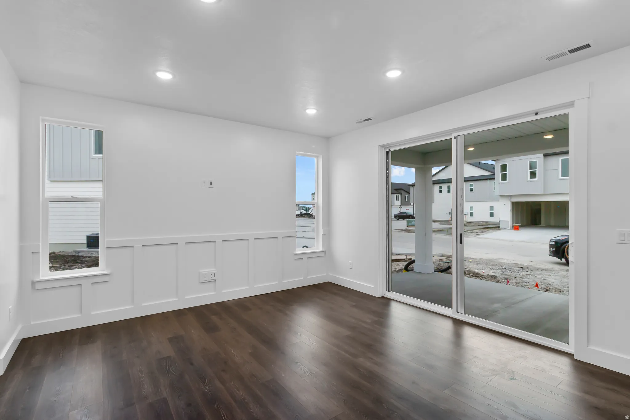 Unfurnished room featuring a wainscoted wall, a decorative wall, dark wood finished floors, and recessed lighting