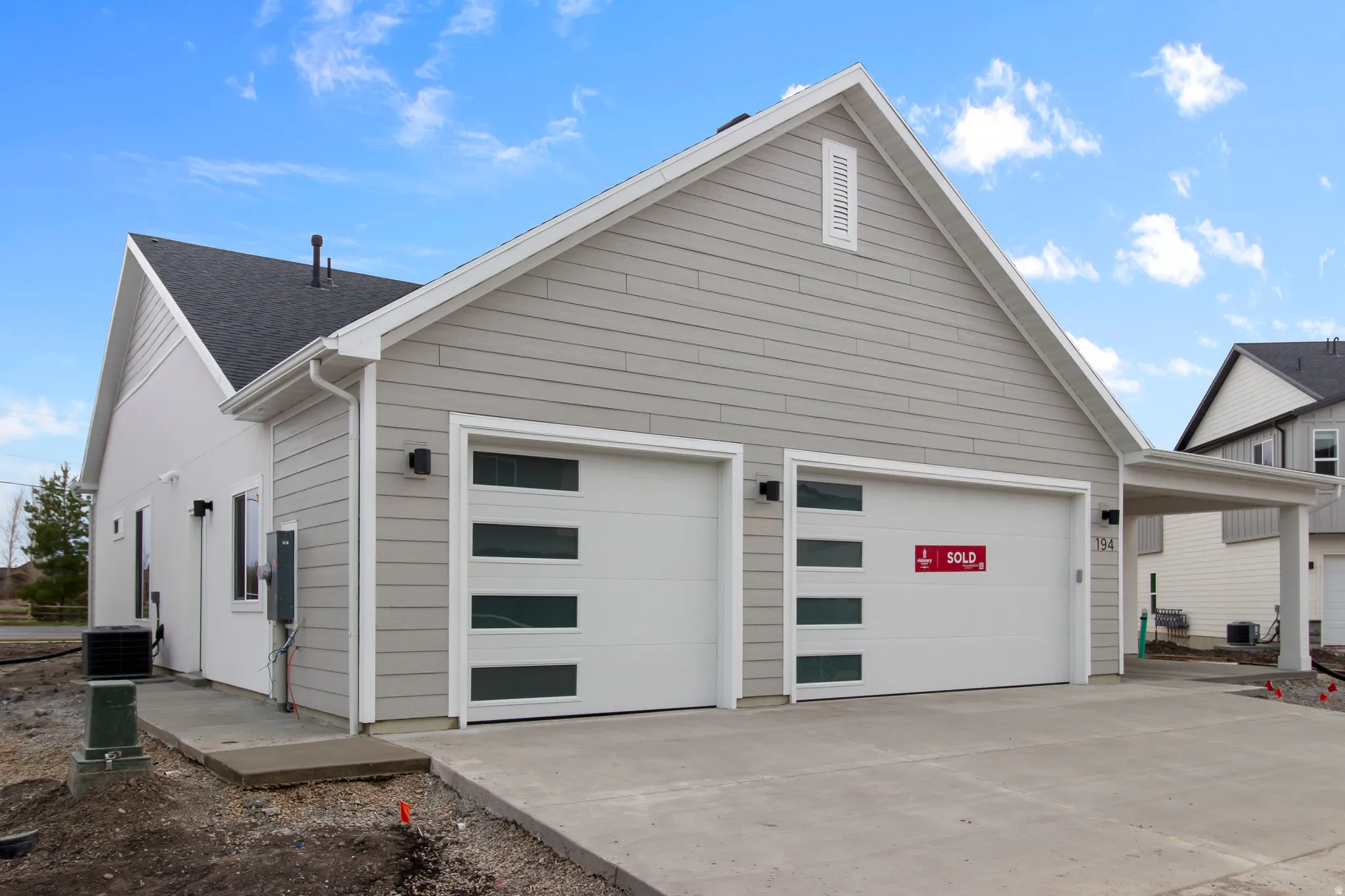 View of side of property with driveway and an attached garage