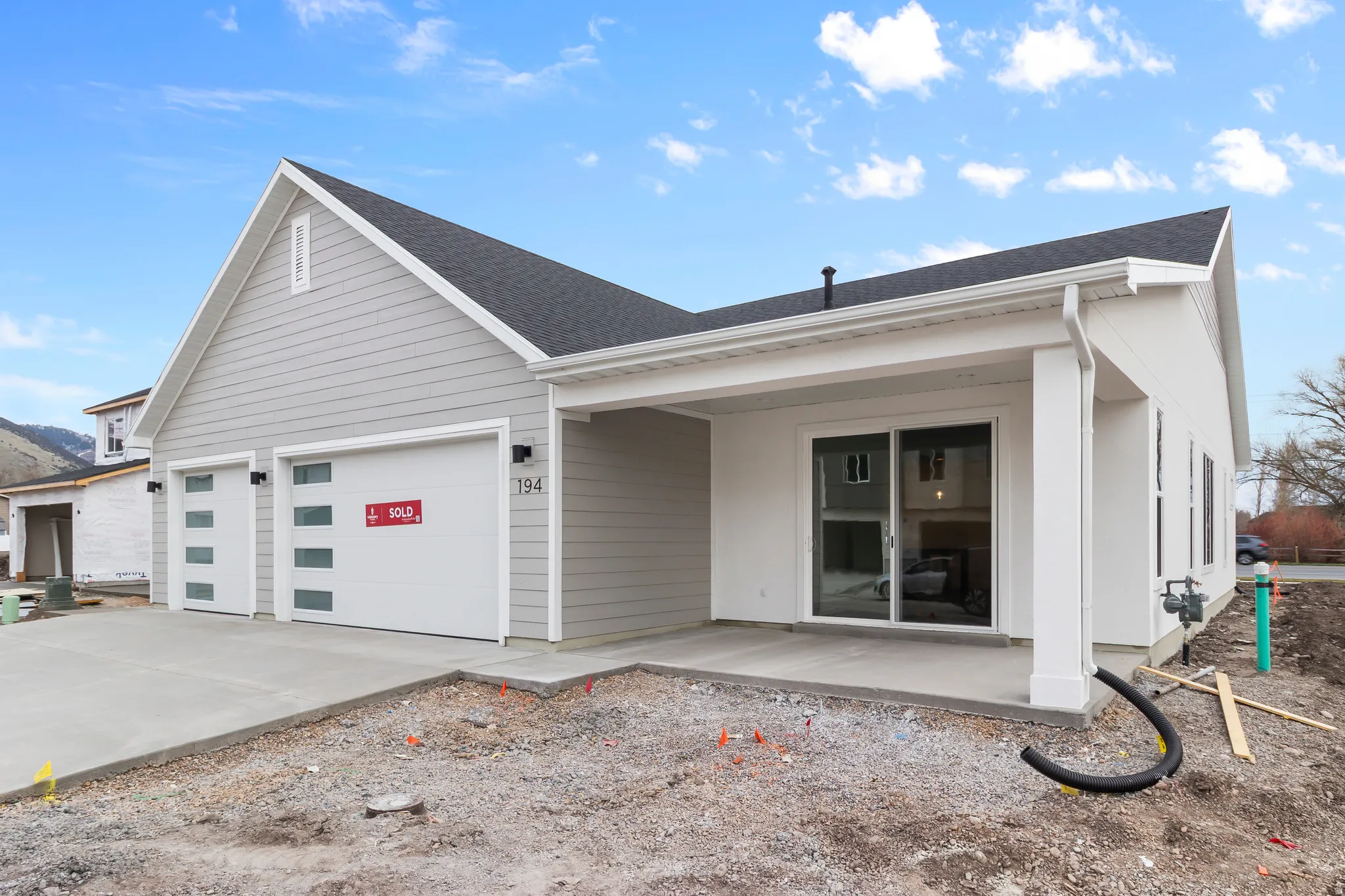 View of front of home with driveway, a garage, and roof with shingles