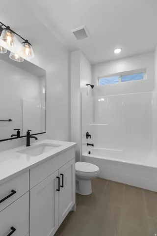 Full bathroom with vanity, bathing tub / shower combination, light tile patterned floors, and recessed lighting