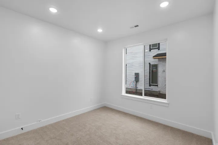 Carpeted empty room featuring baseboards and recessed lighting