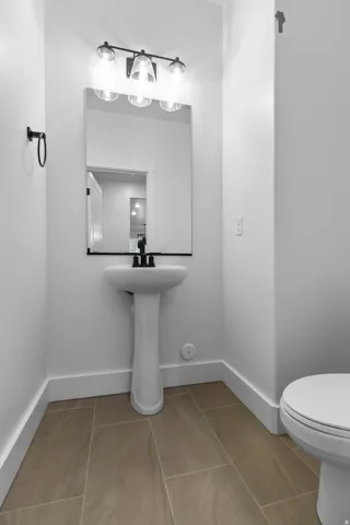 Half bath with light tile patterned flooring