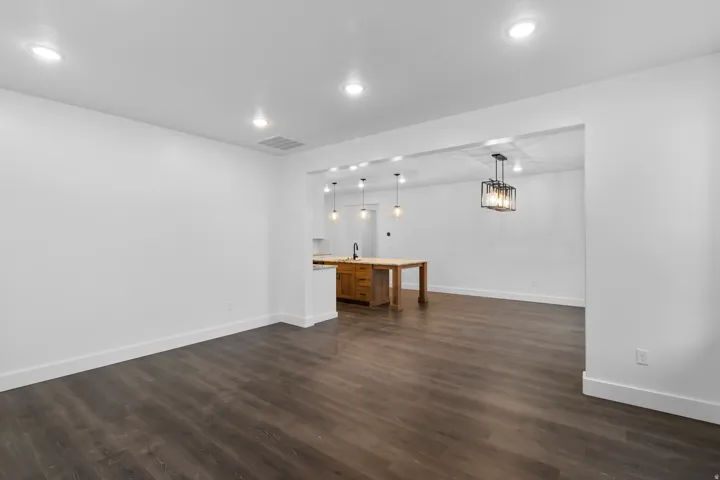 Unfurnished living room with dark wood-style flooring and recessed lighting