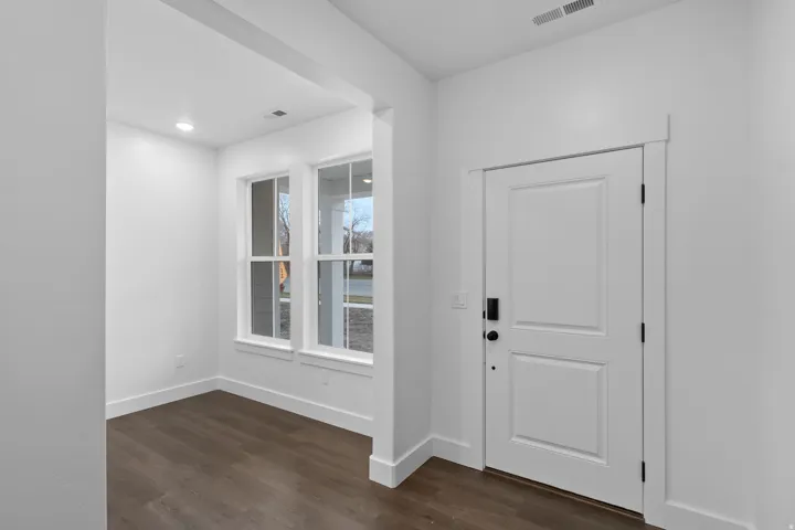 Foyer entrance with dark wood-style floors and recessed lighting