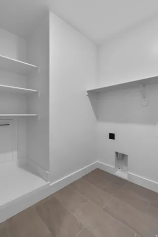 Laundry room with baseboards and hookup for an electric dryer