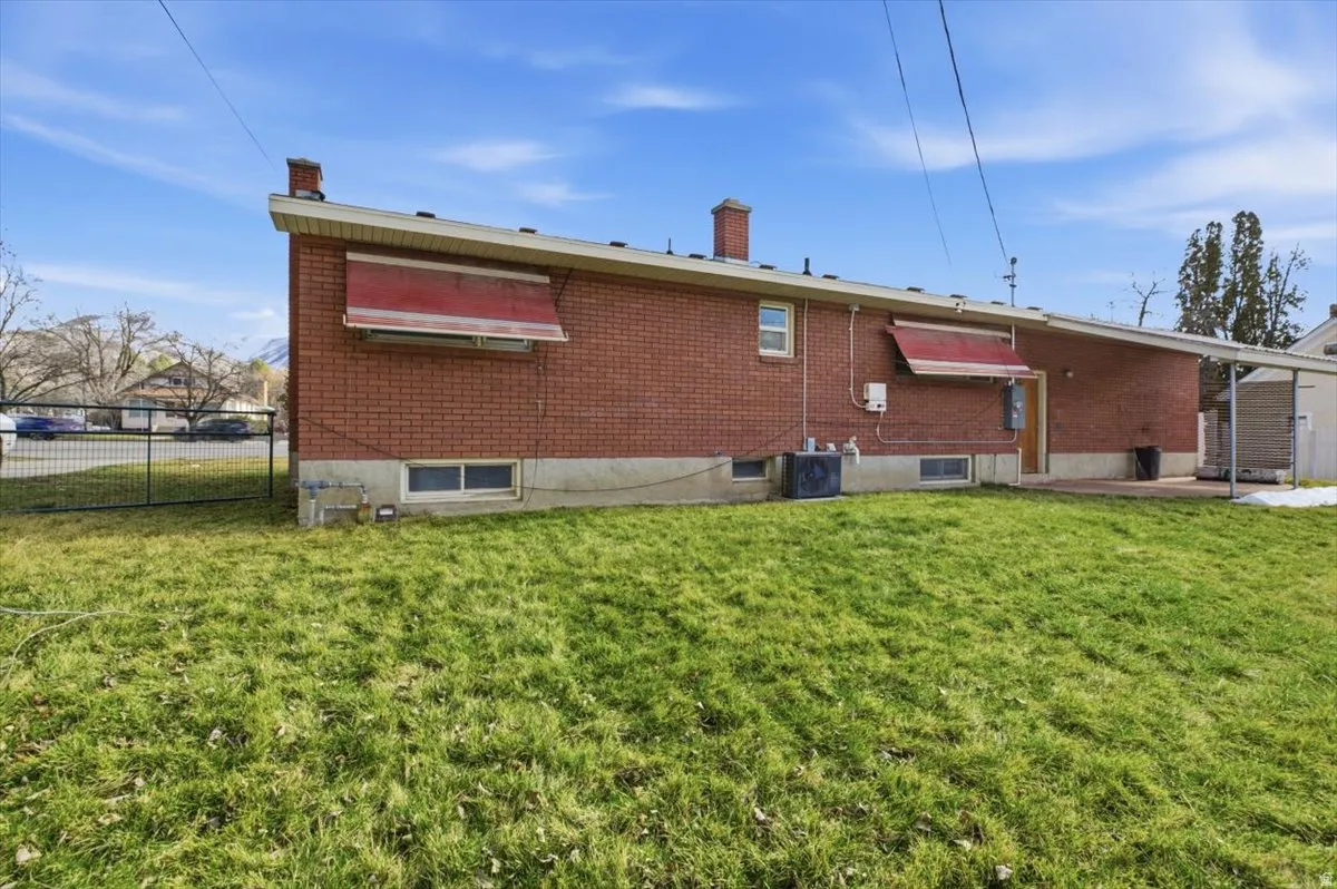 Rear view of property with a chimney, a patio area, and brick siding