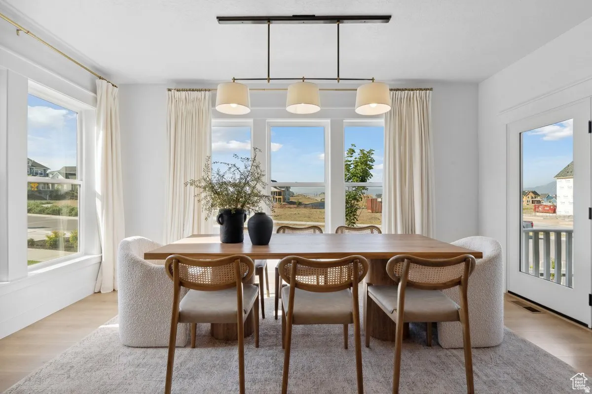 Dining room with wood finished floors, track lighting, and plenty of natural light