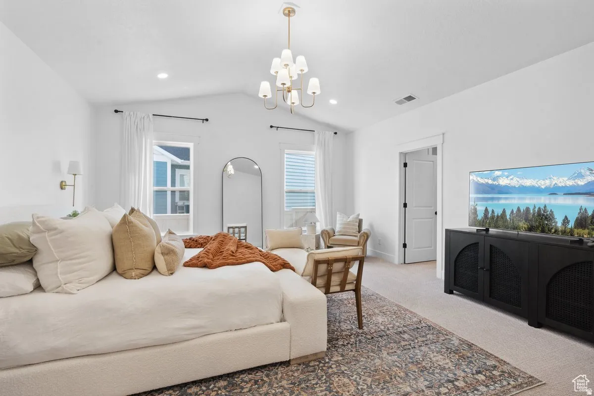 Bedroom featuring light colored carpet and suspended lighting