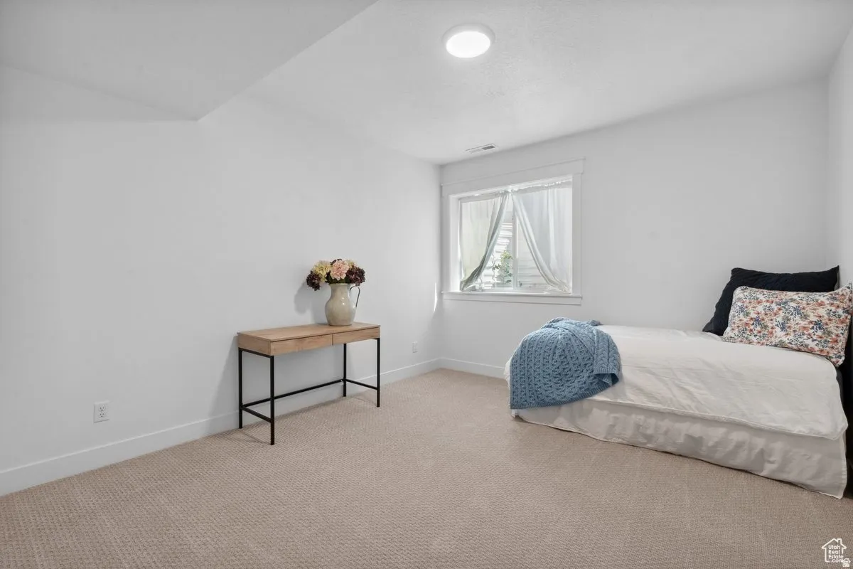Bedroom featuring light colored carpet and baseboards