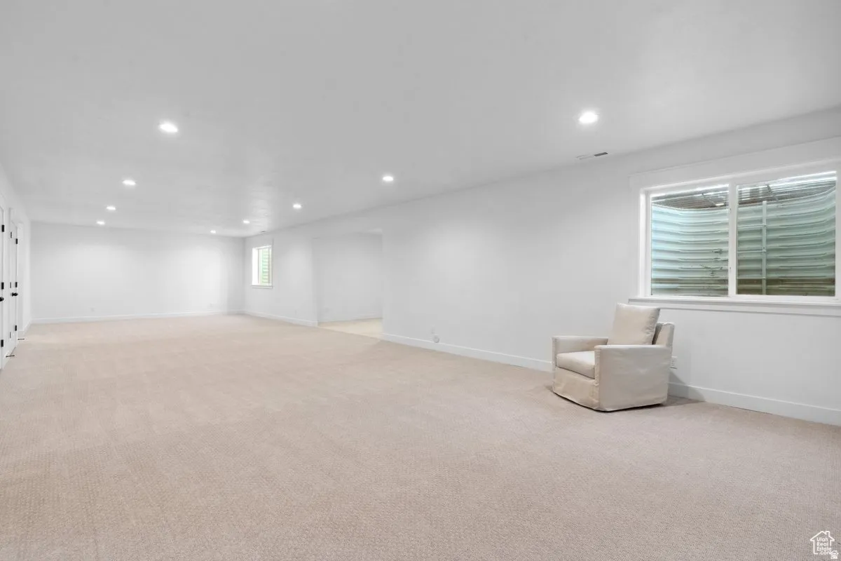 Basement with light colored carpet and recessed lighting