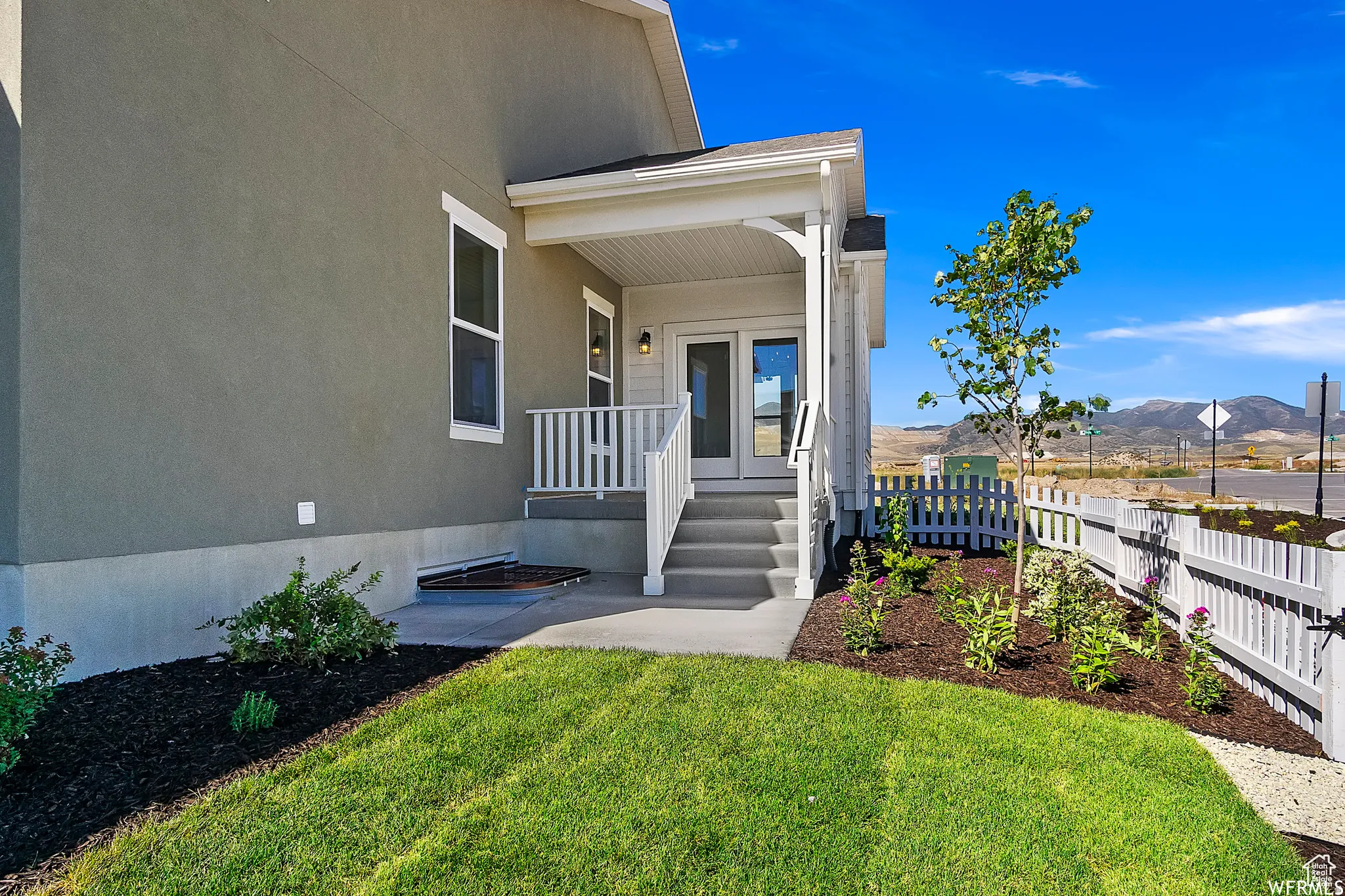 View of exterior entry featuring a mountain view, a patio, and stucco siding
