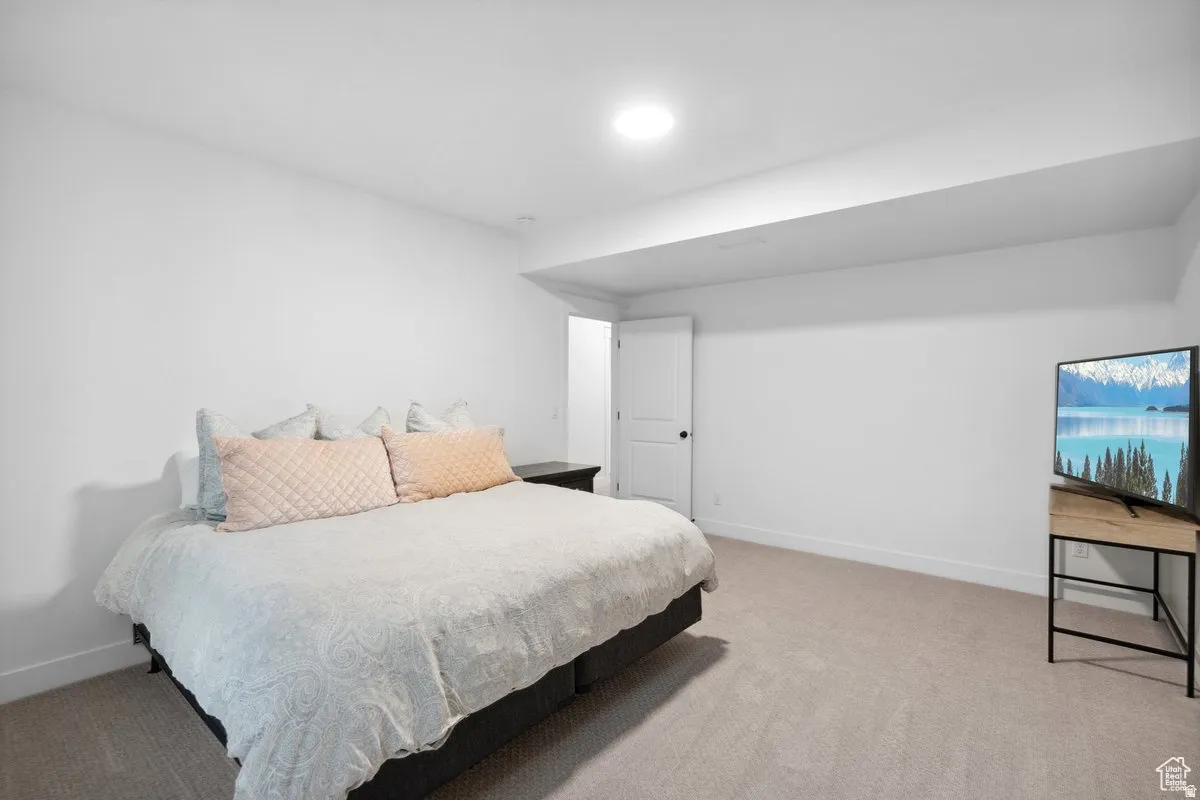 Bedroom featuring baseboards and light colored carpet