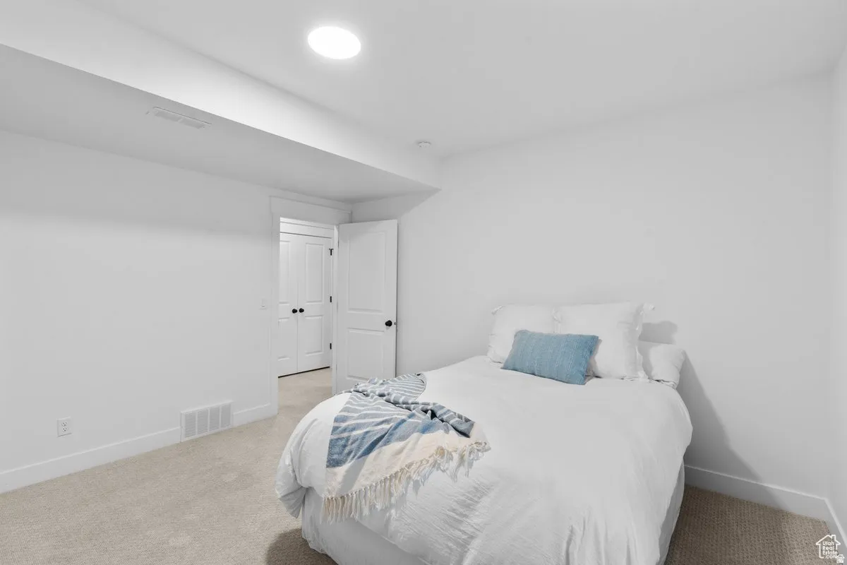 Bedroom with baseboards and light carpet