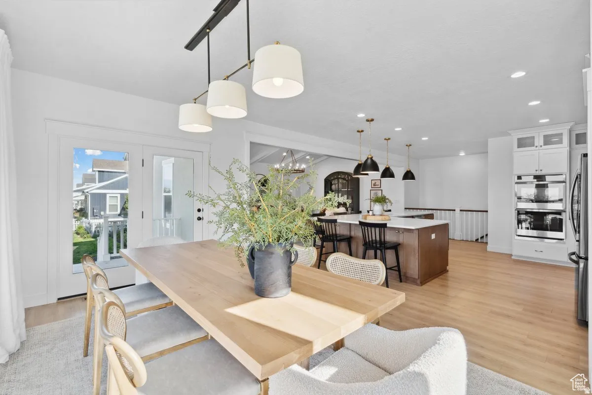 Dining room with light wood finished floors and suspended lighting