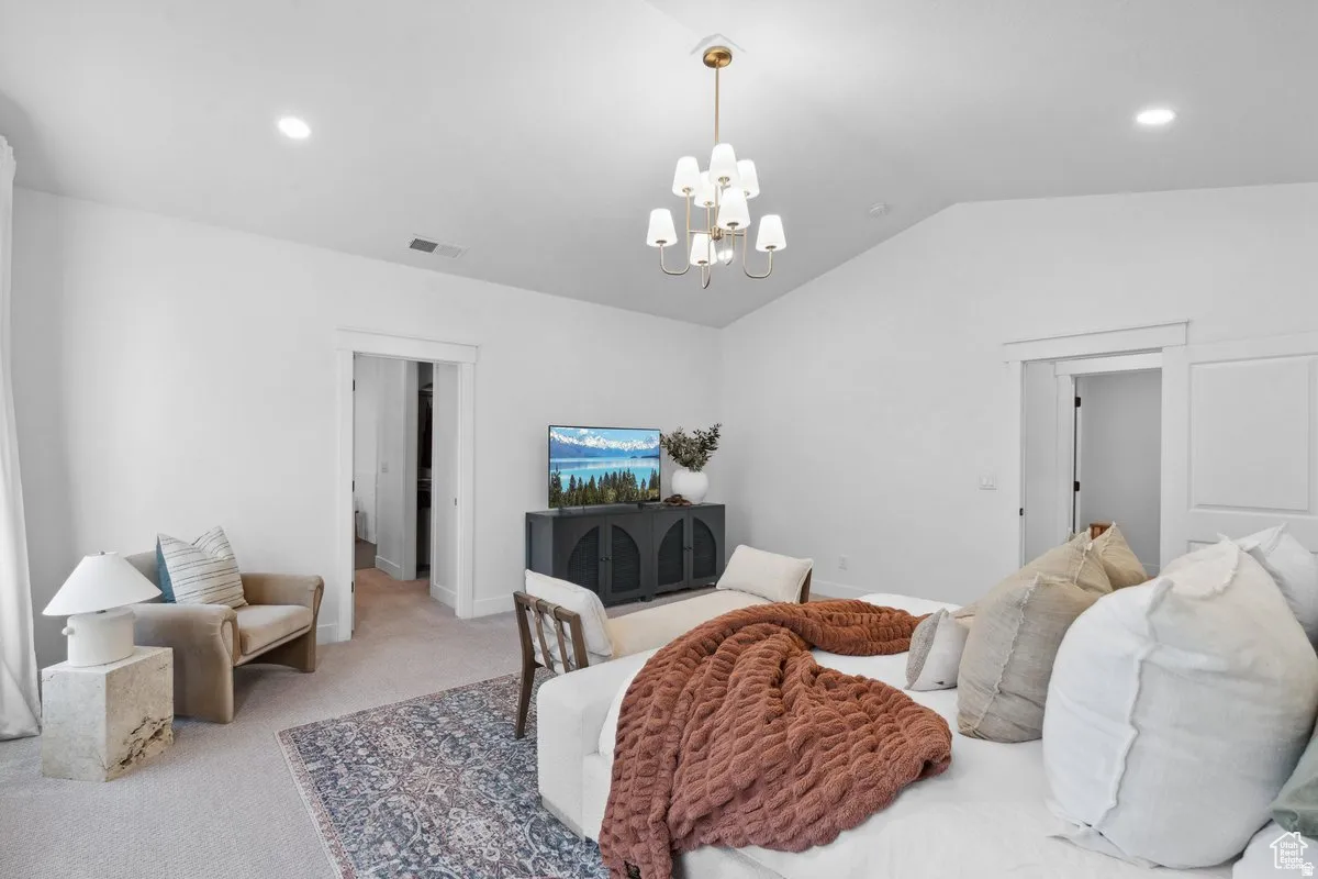 Bedroom featuring light carpet and suspended lighting