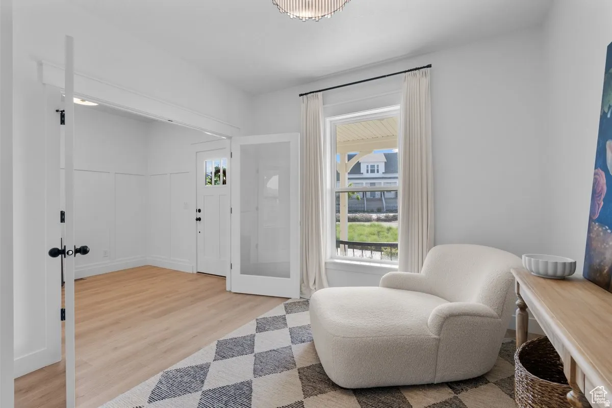 Sitting room with light wood finished floors and french doors