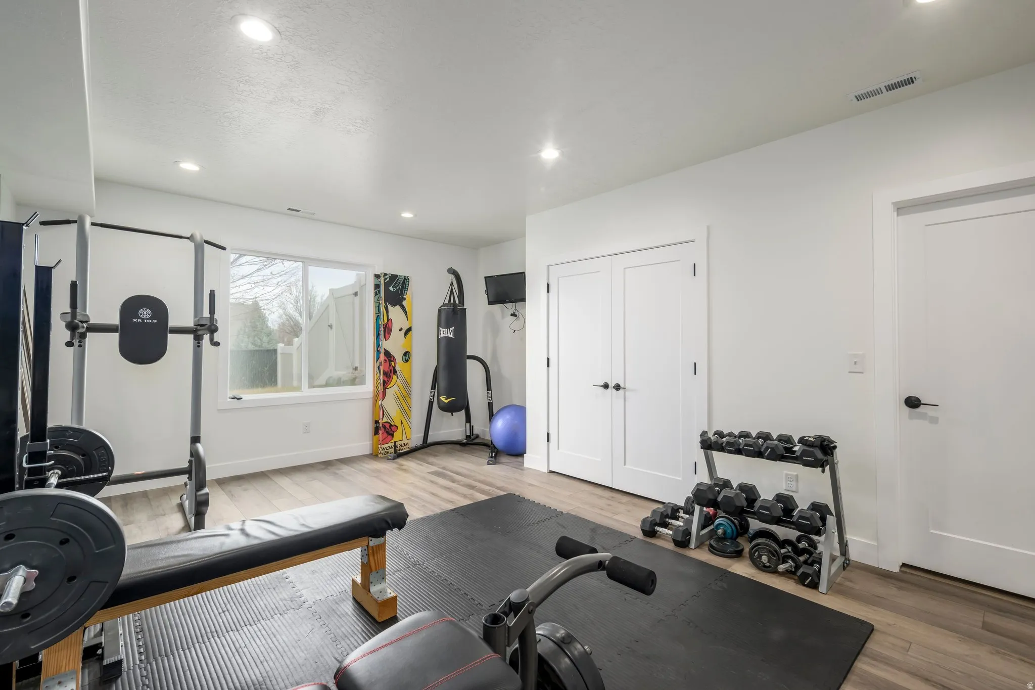 Exercise room featuring light wood-style flooring and recessed lighting
