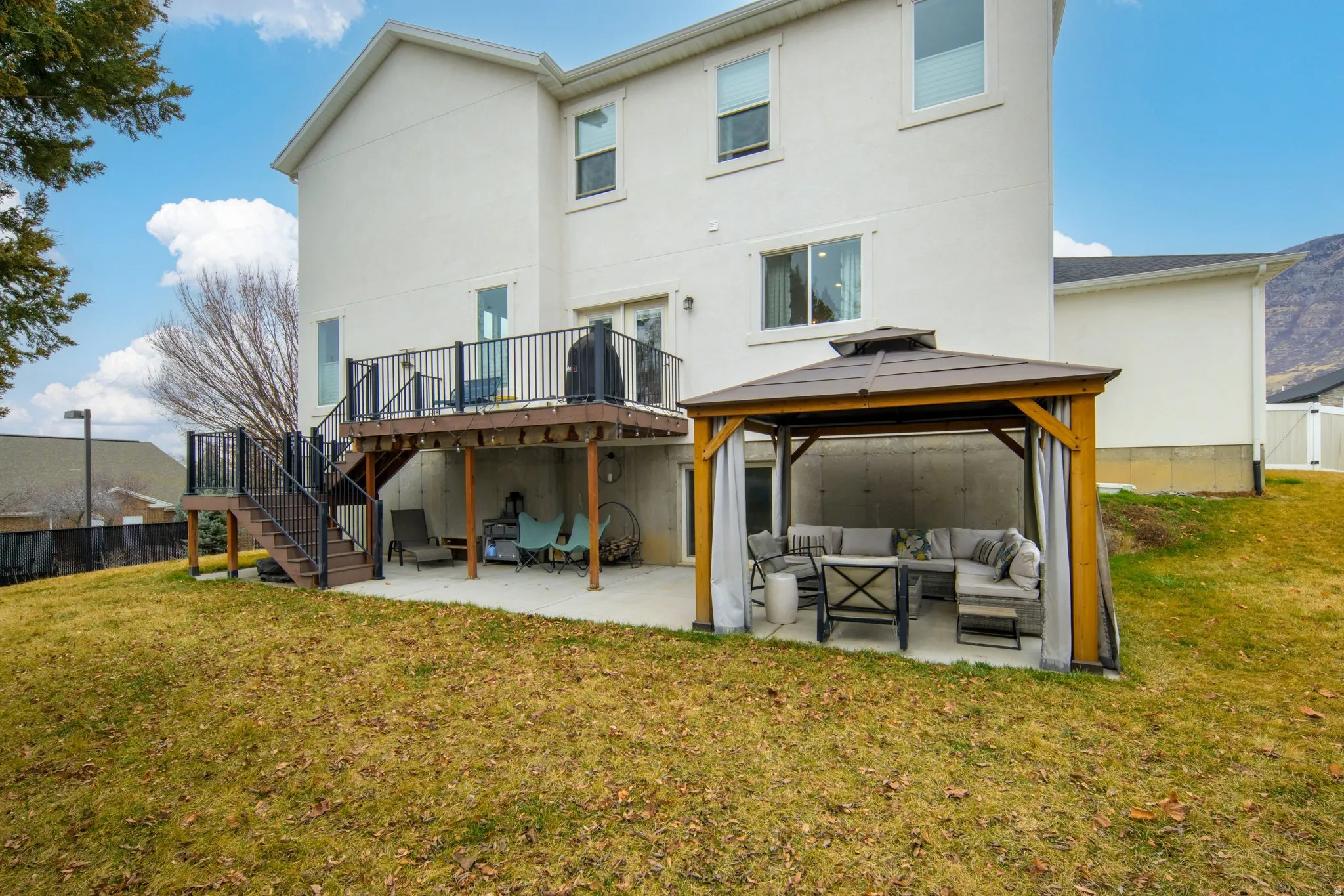 Rear view of property featuring outdoor lounge area, a patio area, stucco siding, a gazebo, and a wooden deck