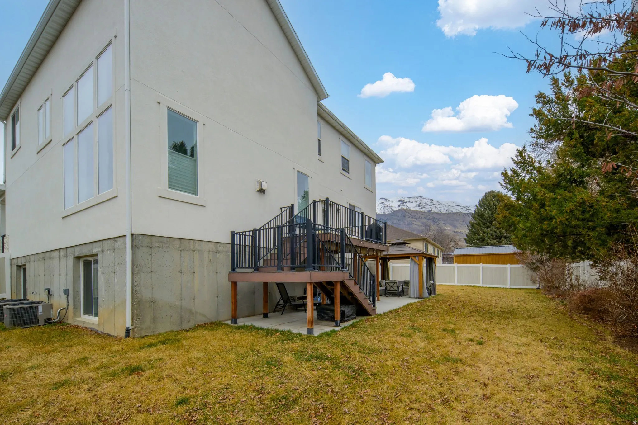 Back of house featuring a patio area, a deck with mountain view, and stucco siding