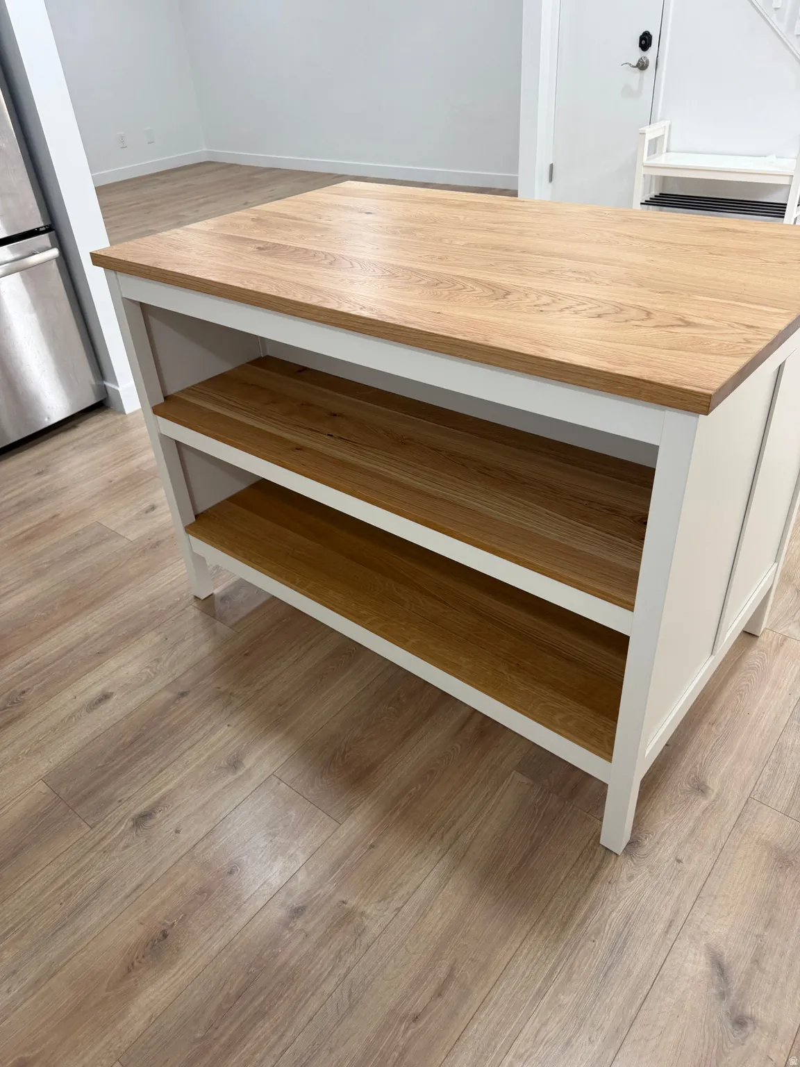 Freestanding kitchen island featuring a wood-finish countertop and two open storage shelves